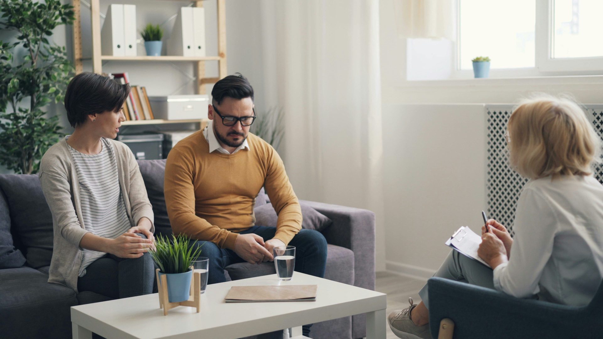 a man and woman sitting on a couch talking to each other