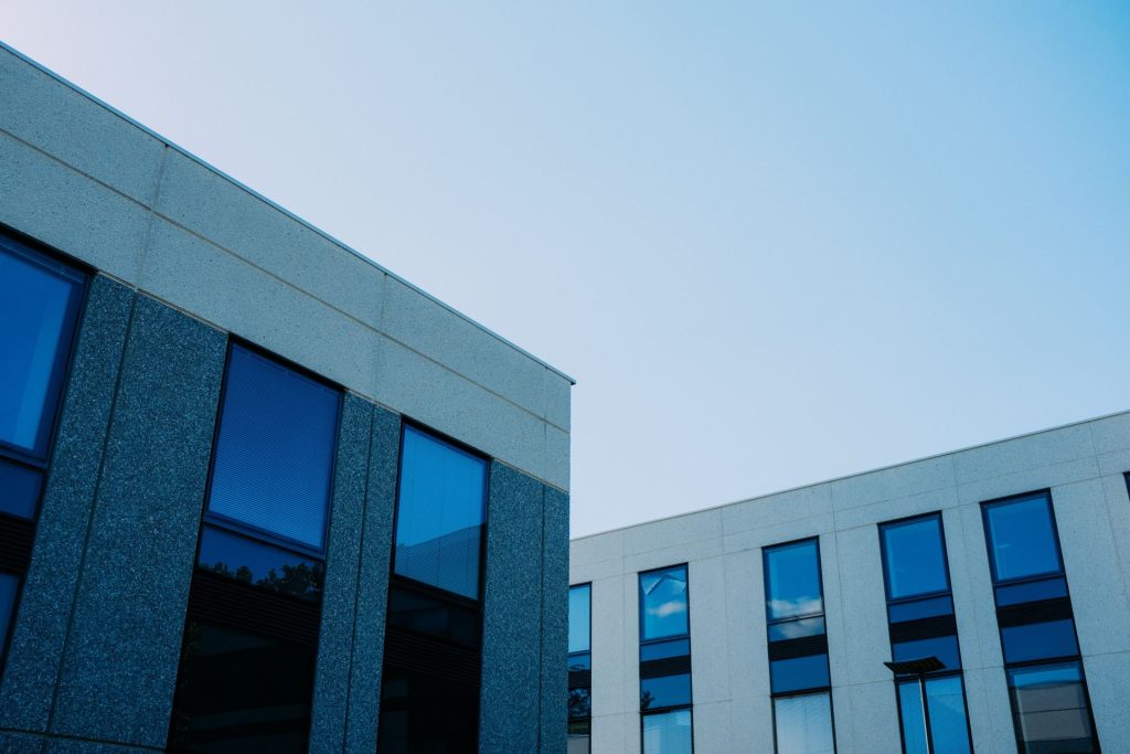 From below of contemporary office buildings with reflection in windows located in city